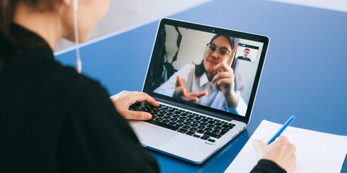 A woman is using a laptop to make a video call for business.