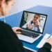 A woman is using a laptop to make a video call for business.