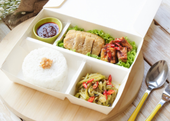 A lunch box with rice, vegetables and meat in it, perfect for a quick meal at work or on the go.