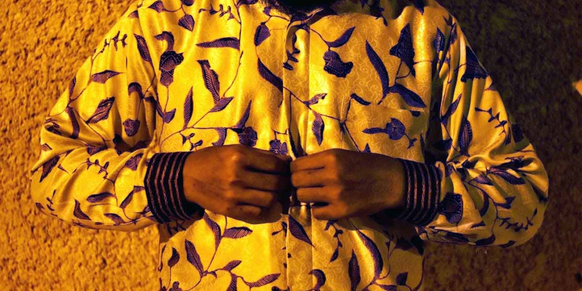 A man wearing a blue and yellow shirt as he reads the latest business news.