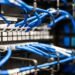 A rack of blue wires in a server room is showcased in business news.