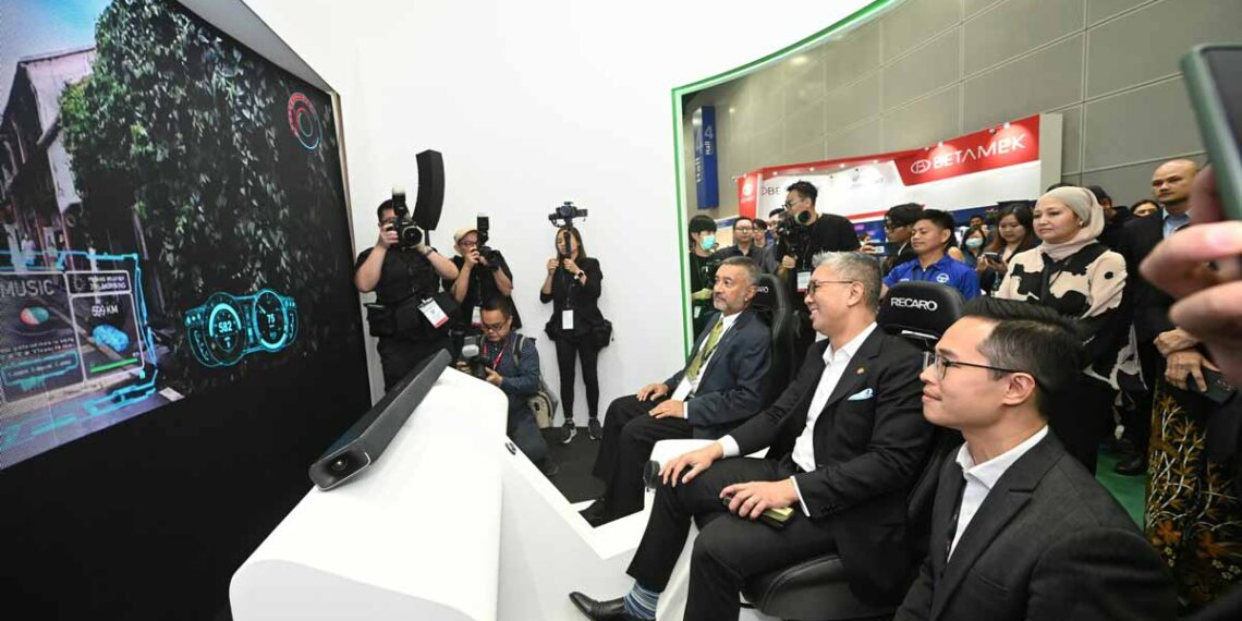 The MITI minister Tengku Zafrul and Maxis Chairman Tan Sri Mokhzani Mahathir at E-Mobility Asia (2023) Exhibition at Kuala Lumpur Convention Centre.