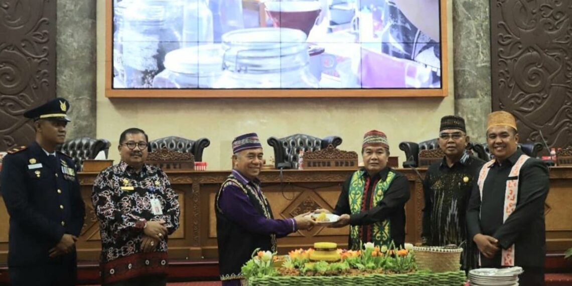 West Kutai Vice Regent Edyanto Arkan (left) handed over a piece of tumpeng to the Speaker of West Kutai DPRD Ridwai (11/04). Image: West Kutai Communication and Informatics Dept. business news