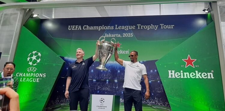 Bastian Schweinsteiger (left) and Luís Nani lift the trophy at UEFA Champions League Trophy Tour 2025 held by Heineken at Ashta, South Jakarta (04/14). Credit: Sinta